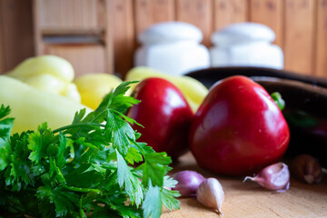Fresh vegetables and herbs arranged on a wooden table for cooking