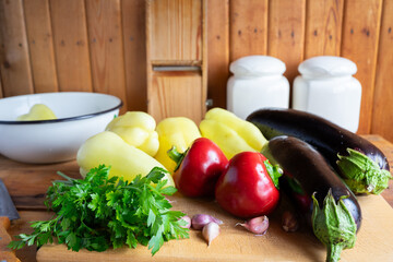 Fresh vegetables arranged on a wooden cutting board in a kitchen setting