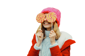 Winter portrait of happy funny smiling young woman in hat having fun with lollipop isolated on white