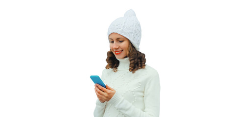 Happy smiling young woman with phone in winter hat, white sweater, girl holding smartphone isolated