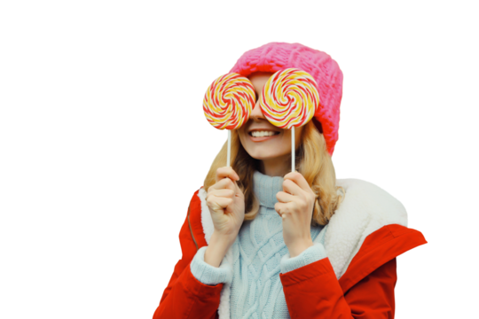 Winter portrait of happy funny smiling young woman in hat having fun with lollipop isolated on white