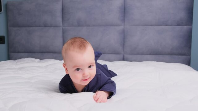A New born amazed active baby boy begins to roll over Child development flipping from back to front by herself bedroom, head shaking try to hol 