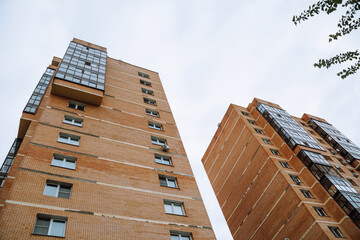 Two tall residential buildings in Irkutsk showcase modern design and urban lifestyle on a cloudy day.