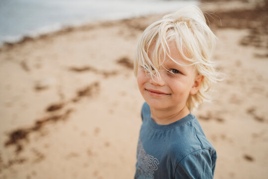 Portrait of a beautiful blonde boy smiling at the beach