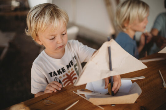 Young kids making boats at campsite with kitchen items