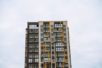 Modern residential building in Irkutsk with striking red accents against a cloudy sky