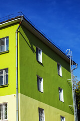 A vibrant residential building in Irkutsk features an orange and green painted facade highlighting urban art.