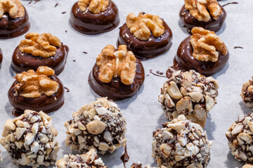 Homemade bite-sized chocolate marzipan candies with nuts on a baking tray