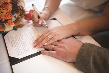 A bride and groom signing the wedding register