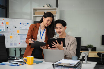 financial asian advisor showing plan of investment to clients in the consultancy office.