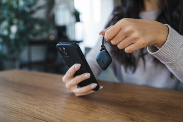 unknown woman hold wireless location accessory token to locate keys