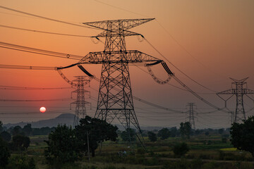 high-voltage power lines at sunset, high voltage electric transmission tower