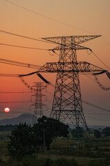 high-voltage power lines at sunset, high voltage electric transmission tower