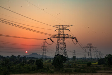 high-voltage power lines at sunset, high voltage electric transmission tower