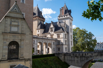 Large building with a tower and a small building in the background. The large building has a lot of windows and a balcony, Pau, France