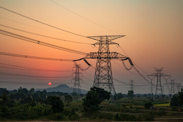 high-voltage power lines at sunset, high voltage electric transmission tower