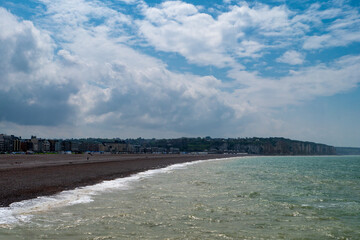 Beach with a cloudy sky in the background. The beach is empty and the water is calm, Dieppe, France