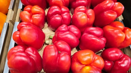 Sweet peppers stacked on a counter for sale. Large colored product.
