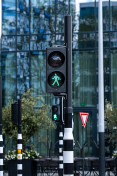 This image captures a vibrant green pedestrian signal against a backdrop of modern architecture, illuminating the importance of pedestrian-friendly urban design.
