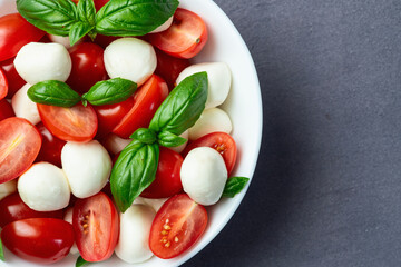 Basil leaves , cherry tomatoes and mozzarella cheese . In bowl food photography