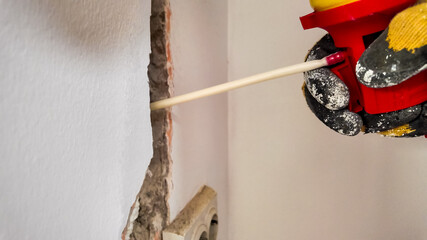 A person applies foam sealant into a wall crack, addressing home insulation and repair issues...