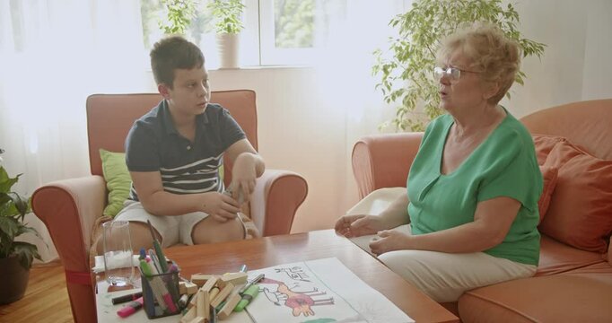 A grandmother and grandson bond over a game of cards, showcasing the joy of family connections and inter generational relationships.