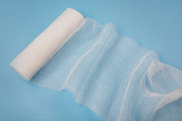 Gauze medical bandage. Unwound medical bandage on a blue background.