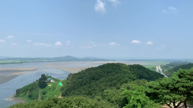 South Korea and North Korea border in the middle of Han and Imjin rivers. DMZ zone. Low tide. View from Odusan Unification Observation Deck. Movement of cars on a highway on  South Korean side