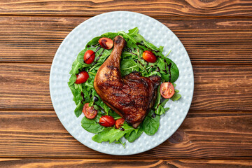 Grilled chicken legs with tomatoes and salad . Top view
