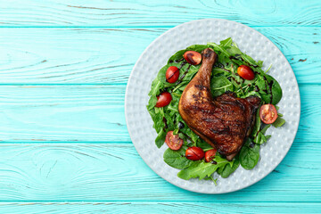 Grilled chicken legs with tomatoes and salad . Top view