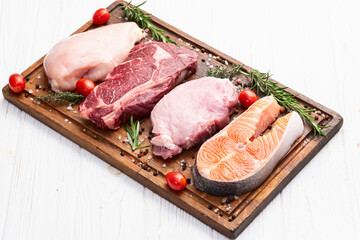 Mix of raw meat and fish . Salmon , beef , pork , chicken staek . Top view