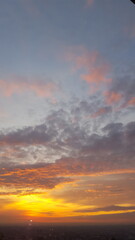 Obraz premium With the setting sun, the sky bursts into vibrant tones of amber and scarlet, adorned with expansive clouds, forming a mesmerizing scene with an intense fiery hue.