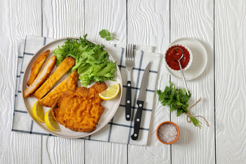 Pork Milanese with lettuce and lemon on a plate