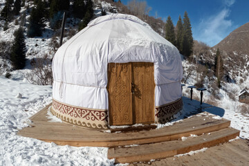 Traditional Central asian nomadic home yurt with a wooden door in the Tian Shan mountains.