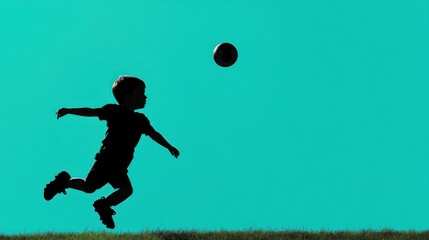Naklejka premium Boy silhouetted playing soccer, kicking ball.