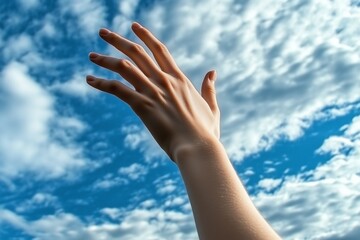 woman holding out her hand to the blue sky with clouds, hope and faith concept