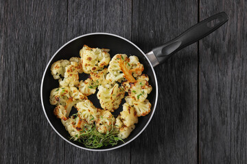 fried cauliflower florets on a skillet, top view