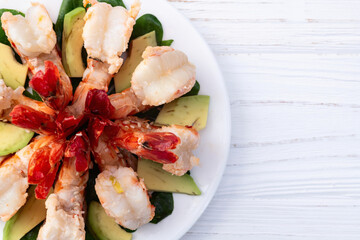 Salad with tiger shrimps , avocado and mango . Top view