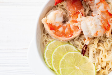 Tom yum soup with shrimps instant noodles and lime photography . Asian food . Top view