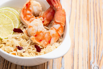 Tom yum soup with shrimps instant noodles and lime photography . Asian food . Top view