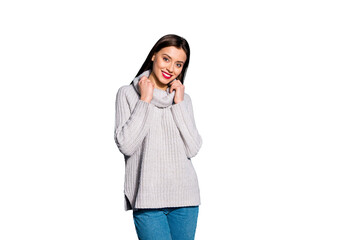 Portrait of pretty lady looking at camera with beaming smile touching her jumper isolated over blue background