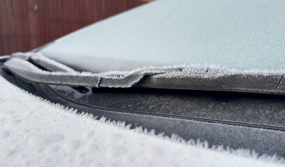 frozen windshield wiper. concept of dangerous driving during the winter season.