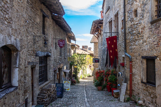 France, P&eacute;rouges, Auvergne Rh&ocirc;ne Alpes : October 15 2024 : Old medieval street with stone houses, between light and shadow, in the famous village P&eacute;rouges, Ain.