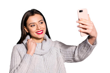 Pretty lady holding telephone hands making selfies wear warm knitted pullover isolated blue...