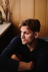 Obraz premium Close-up portrait of handsome young Caucasian man emotionless expression serious face against apartment background