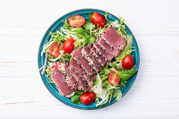 Salad with raw tuna , sesame and cherry tomatoes photography . Top view