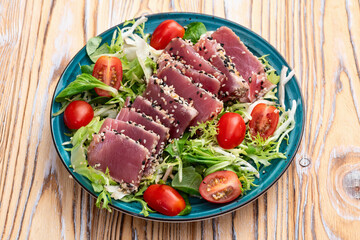 Salad with raw tuna , sesame and cherry tomatoes photography . Top view