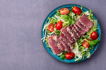 Salad with raw tuna , sesame and cherry tomatoes photography . Top view
