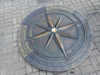 a large metal compass embedded in the sidewalk. Kaliningrad 2024 July 17