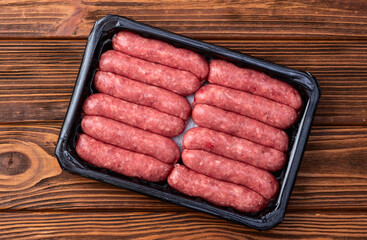 Raw beef sausages with rosemary and tomatoes photography . Top view